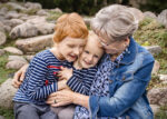 Ourdoor Familien-Fotoshooting bei Rostock - Die Großmutter kuschelt auf diesem Foto mit ihren beiden Enkelkindern, alle lächeln und sind happy